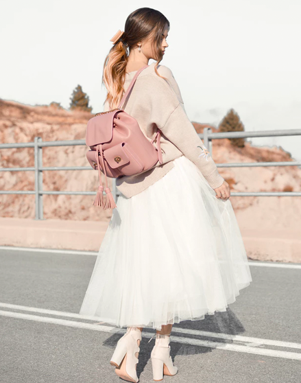 Modeling white puffy skirt, pink cardigan and pink leather bag.